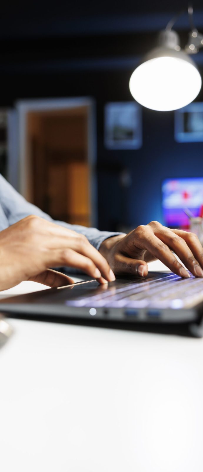 Remote tasks for company worker focusing on monthly earnings balance using legitimate financial details and web outputs. African american man manages his accounting tasks. Close up.